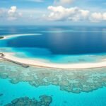 Gyönyörű trópusi strand a Maldív-szigeteken tiszta vízzel és korallzátonyokkal.