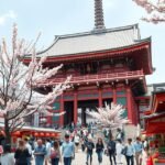 Senso-ji templom Asakusában, cseresznyevirág és látogatók a kapu előtt.