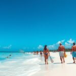 Látogatók sétálnak Cancún strandján napfényes időben.