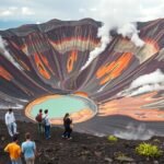 Aso-hegyi vulkánkráter Kumamoto körpanorámájával és túrázókkal.