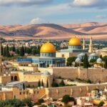 Jeruzsálem panorámaképe, arany kupolájú mecsettel és hegyekkel a háttérben.