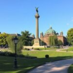 A Győzelmi oszlop a berlini Tiergarten parkban, zöldellő fákkal körülvéve.