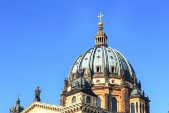 A Berlini Dóm kupolája világos kéken a tiszta égbolt alatt.