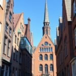 Böttcherstraße látképe Brémában, vöröstégla épületekkel és tornyokkal.