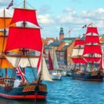 Színes vitorlások tűnnek fel Rostock kikötőjében a Hanse Sail fesztivál alatt.