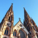 A Szent Péter-dóm gótikus tornyai Regensburgban, kék háttérrel.