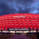 Az Allianz Arena, a Bayern München stadionja éjszaka piros fénnyel világítva.