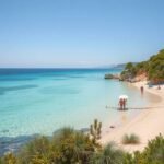 Csendes homokos tengerpart Horvátországban pálmafákkal és kristálytiszta vízzel.