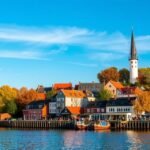 Middelfart városa őszi időben, vízparti házakkal és hajókkal.