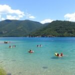 Tóban úszó emberek a napfényben, gyönyörű környezetben