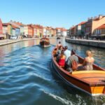 Hajókázás Aveiro csatornáin moliceiro csónakkal, színes házak között.