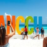 Látványos CANCUN felirat a Playa Delfines tengerpartján napfényben
