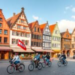 Kerékpárosok a Prinzipalmarkt történelmi épületei között Münsterben.