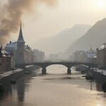 A folyó partján álló város, a háttérben füsttel és ködben.