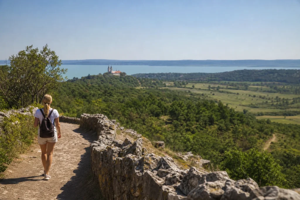 Nő gyalogol a Tihanyi-félszigeten, levendulamezők mellett.