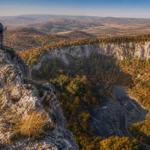 Őszi panoráma a Bél-kőről, túrázó a sziklán állva