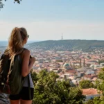 Nő városnézés közben a Mecsek felett, Pécs panorámája.